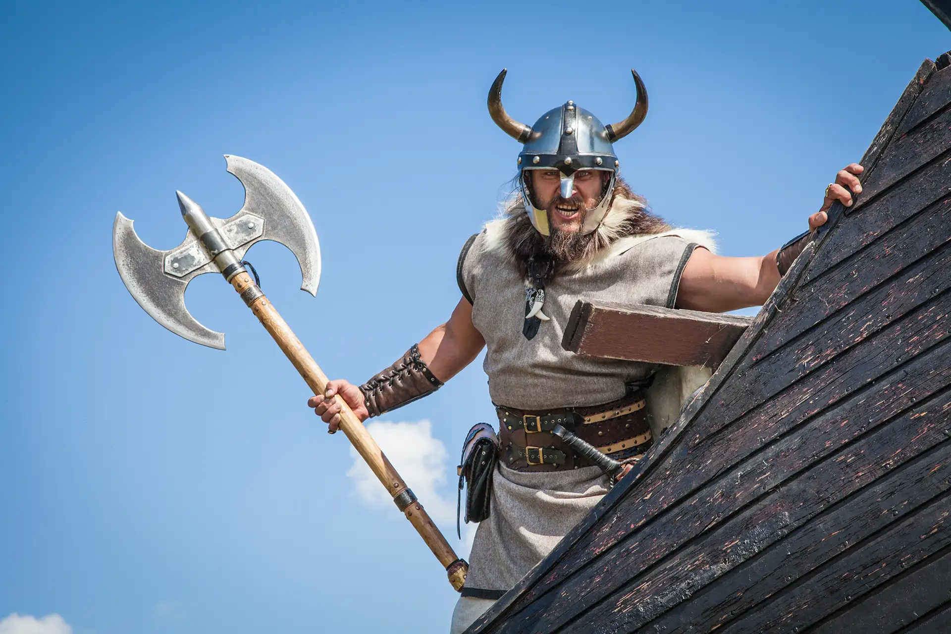 Jorvik Viking reenactor in traditional costume holding a double-sided axe in York, UK.